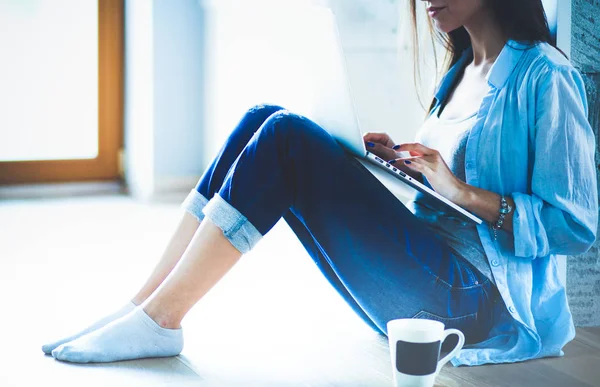 Young beautiful woman at home sitting on the floor with laptop. Young beautiful woman. — Stock Photo, Image