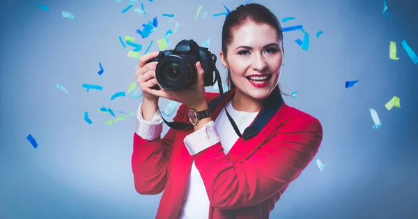 Hermosa mujer feliz con cámara en la fiesta de celebración con confeti. Cumpleaños o Nochevieja celebrando el concepto — Foto de Stock