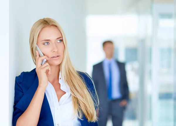 Podnikatelka stojí u okna kanceláře a mluví na mobilu. Obchodnice — Stock fotografie