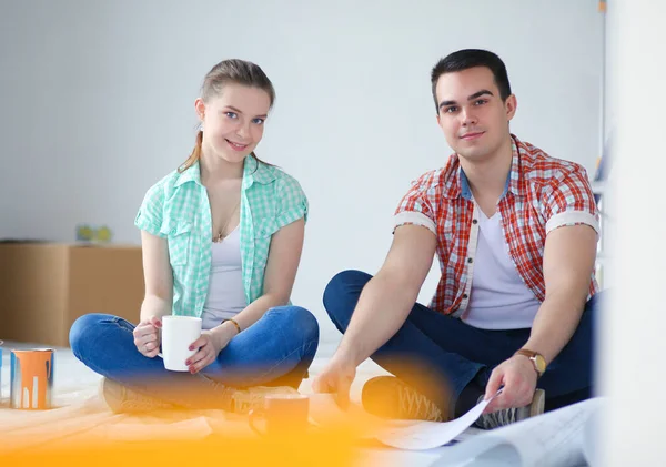 Junges Paar auf dem Fußboden sitzend und über ihre Ersparnisse rechnend. junges Paar — Stockfoto