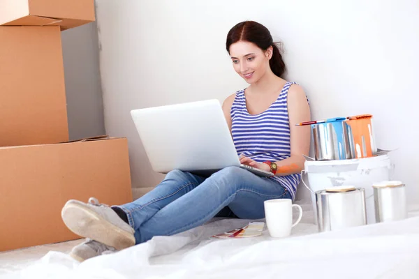 ノート パソコンに座っての新しいアパートを描きながら若い女性の肖像画。ラップトップを持つ若い女性 — ストック写真