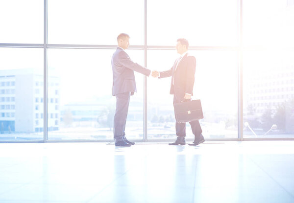 Изображение двух успешных бизнесменов, пожимающих друг другу руки