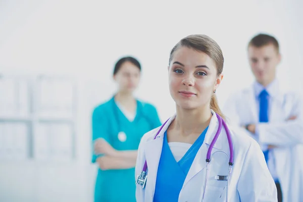 Attractive female doctor in front of medical group. — Stock Photo, Image