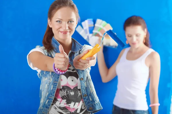 Dos hermosas mujeres jóvenes pintando paredes. Dos Hermosa joven mujer —  Fotos de Stock