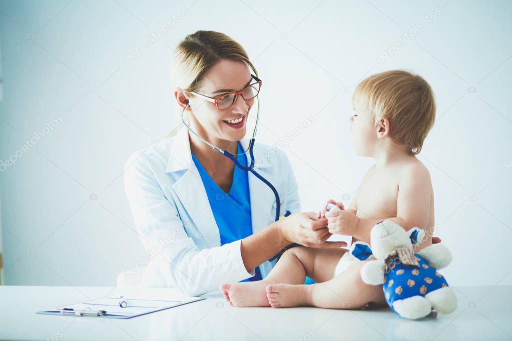 Female doctor is listening kid with a stethoscope in clinic