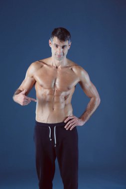 kaslı adam. Kaslı adam kas gösterilen gri arka plan üzerinde. Fitness Eğitmeni. Fitness profesyonel. Egzersiz. Mens fitness.