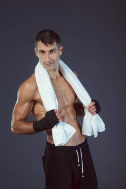 Siyah arka plan üzerine ayakta güçlü atletik adam.