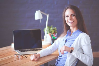 Masada oturan genç bir kadın..