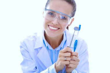 Güzel bir dişçi kadın doktor beyaz arka planda izole edilmiş diş fırçasını tutuyor. Dişçi doktor.