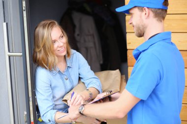 Mavi üniformalı gülümseyen kurye servis konseptine paket kutusu teslim eden teslimatçı. Mavi üniformalı gülümseyen teslimatçı.