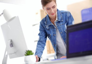 Masanın yanında duran iki genç kadın enstrüman, plan ve dizüstü bilgisayarla.