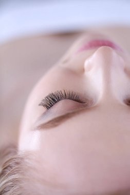 Masaj masasında uzanmış gözleri kapalı rahatlayan genç bir kadın. - Kadın. Spa salonu