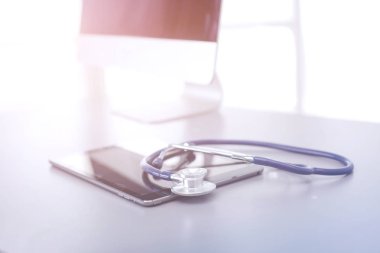 Tıbbi ekipman: Beyaz arka planda mavi steteskop ve tablet. Tıbbi ekipman