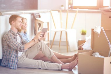 Genç bir çift yeni ev içinde hareket. Oturma ve açma sonra rahatlatıcı. Bir şey üstünde laptop arıyorum. Genç Çift