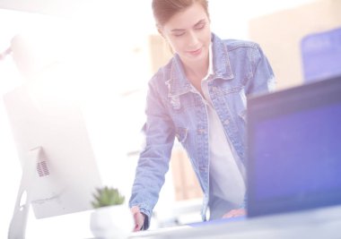 Masanın yanında duran iki genç kadın enstrüman, plan ve dizüstü bilgisayarla.