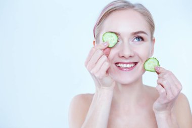 Beyaz zemin üzerine salatalık dilimleri ile genç güzel kadın