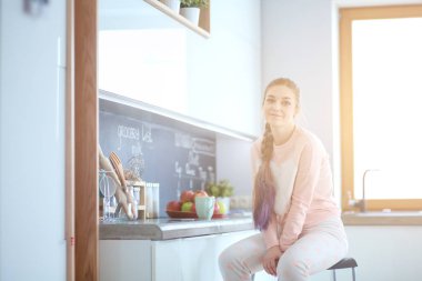 Mutfakta masada oturan genç kadın.