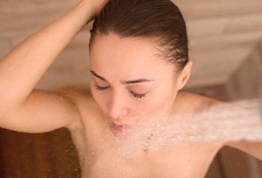 Genç beautyful kadın banyoda duş altında.