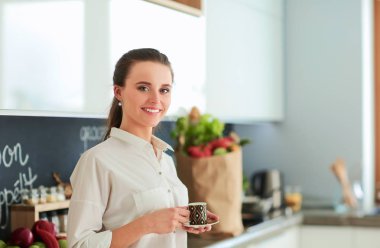 Giderleri planlama ve mutfağını faturalarında ödeme genç kadın.