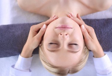 Masaj masasında uzanmış gözleri kapalı rahatlayan genç bir kadın. - Kadın. Spa salonu