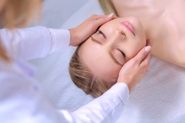 Masaj masasında uzanmış gözleri kapalı rahatlayan genç bir kadın. - Kadın. Spa salonu