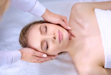 Masaj masasında uzanmış gözleri kapalı rahatlayan genç bir kadın. - Kadın. Spa salonu