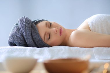 Masaj masasında uzanmış gözleri kapalı rahatlayan genç bir kadın. - Kadın. Spa salonu