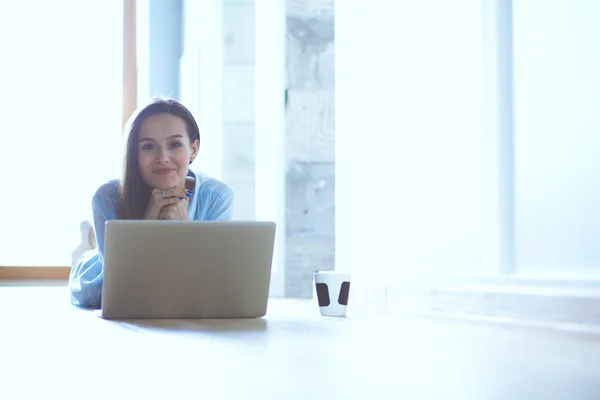 Young beautiful woman at home sitting on the floor with laptop. Young beautiful woman. — Stock Photo, Image