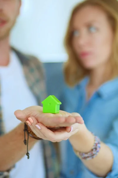 Model huis in handen van een paar, staan in de nieuwe woning. Model huis. — Stockfoto