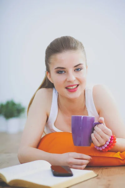 Jeune femme souriante couchée sur un sol blanc avec oreiller . — Photo