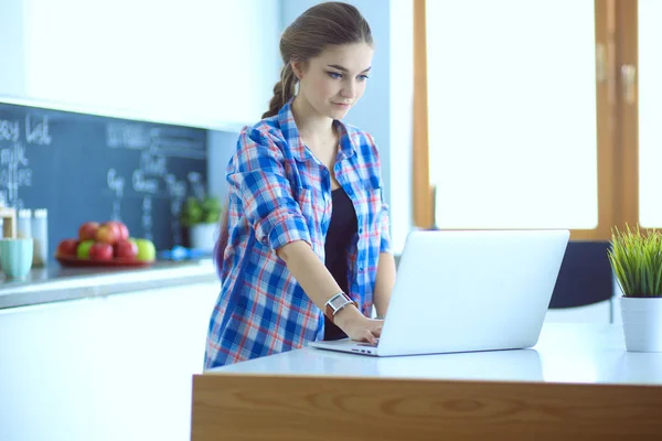 Mooie jonge glimlachende vrouwelijke arts zitten aan het bureau en schrijven. — Stockfoto