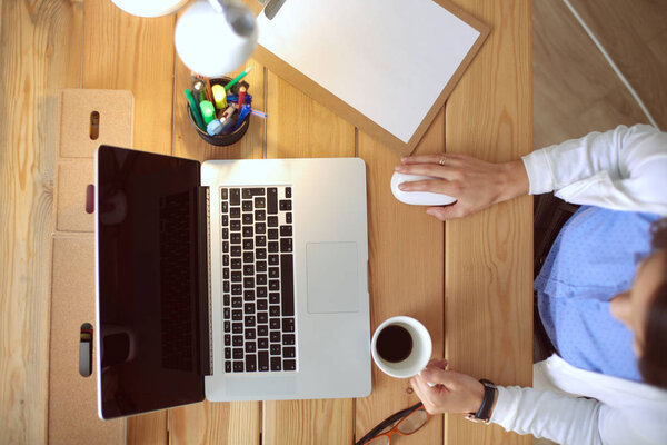 Young female working sitting at a desk.