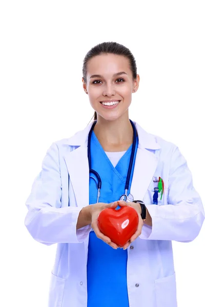 Médico femenino positivo de pie con estetoscopio y símbolo rojo del corazón aislado. Mujer doctora — Foto de Stock