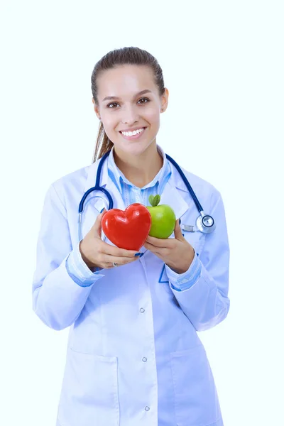 Hermosa doctora sonriente sosteniendo corazón rojo y manzana verde. Mujer doctora —  Fotos de Stock