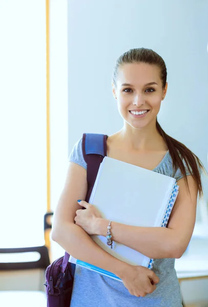 Retrato de una joven estudiante sosteniendo libros de ejercicios. Estudiante mujer —  Fotos de Stock