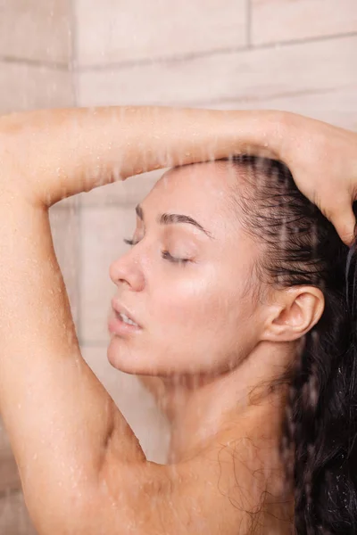 Junge schöne Frau unter der Dusche im Badezimmer. — Stockfoto