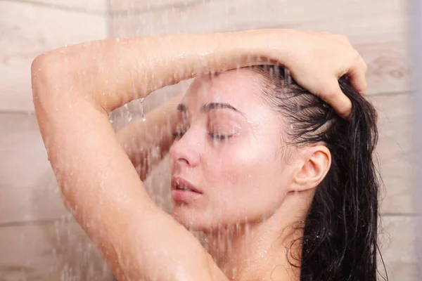 Jeune femme belle sous la douche dans la salle de bain . — Photo