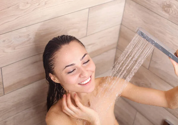 Joven mujer hermosa bajo la ducha en el baño . —  Fotos de Stock