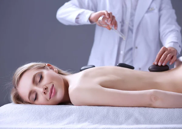 Jovem deitada em uma mesa de massagem, relaxando com os olhos fechados. Mulher. Salão de Spa — Fotografia de Stock