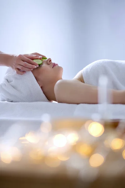 Jovem deitada em uma mesa de massagem, relaxando com os olhos fechados. Mulher. Salão de Spa — Fotografia de Stock