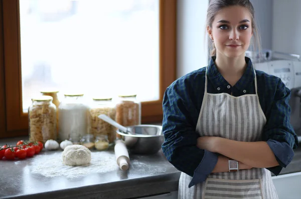 Jeune femme debout près de la cuisinière dans la cuisine . — Photo
