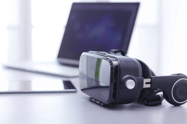 Virtual reality goggles on desk with laptop. business. 3d technology