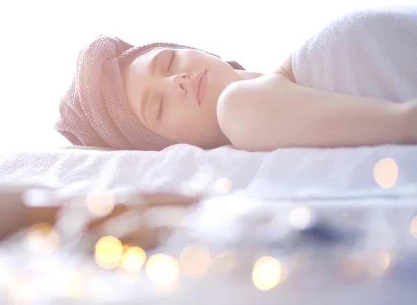 Jonge vrouw liggend op een massagetafel, ontspannend met gesloten ogen. Vrouw. Kuuroord — Stockfoto