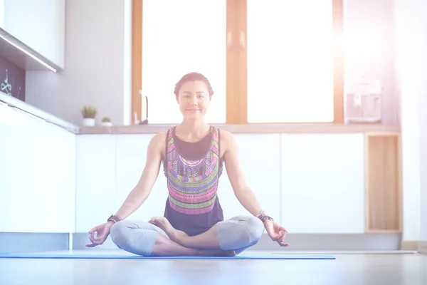 Mujer joven haciendo yoga en casa en la posición de loto. Yoga. Una mujer. Estilo de vida — Foto de Stock