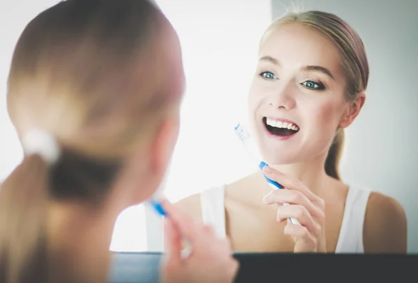 歯磨きの後、鏡で見ている若い女性 — ストック写真