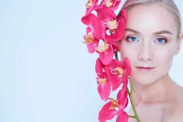 Jeune femme de beauté avec fleur près du visage — Photo