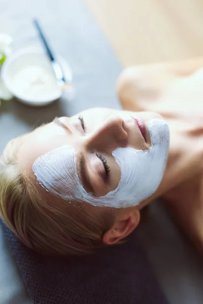 Mascarilla facial. Hermosa joven en el spa, mujer cosmética aplicando mascarilla facial —  Fotos de Stock