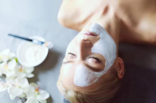 Ansiktsmask. Vacker ung flicka på spa, cosmetician kvinna tillämpa ansiktsmask — Stockfoto