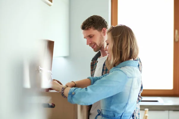 Pareja joven que lleva la caja de cartón grande en el nuevo hogar.Mudanza de la casa. Pareja joven — Foto de Stock