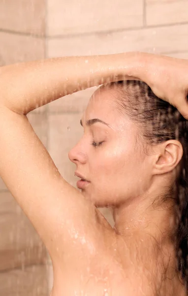 Joven mujer hermosa bajo la ducha en el baño . —  Fotos de Stock